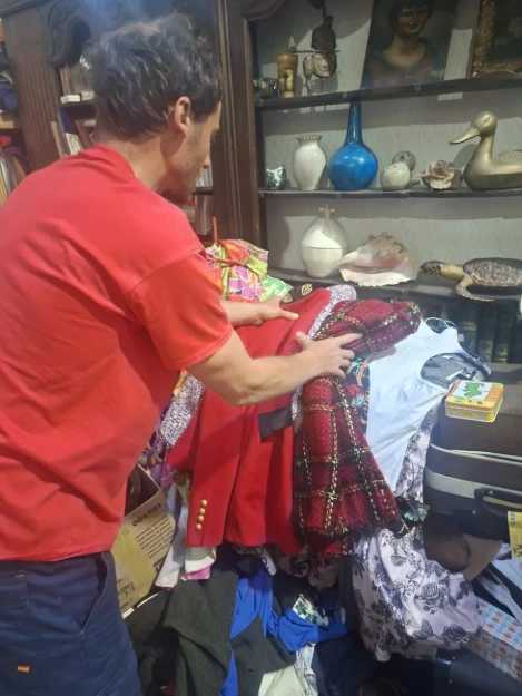 Un membre de l’équipe examine un vêtement pour évaluer son potentiel de réemploi ou de revente. GRAND VIDE : tri des vêtements et valorisation des biens à Paris 2e (75002), secteur Réaumur côté 2e, Rue Montmartre côté 2e, Opéra côté 2e. Devis gratuit sur place ou par photos et vidéos WhatsApp ; valorisation et rachat possibles selon les biens.